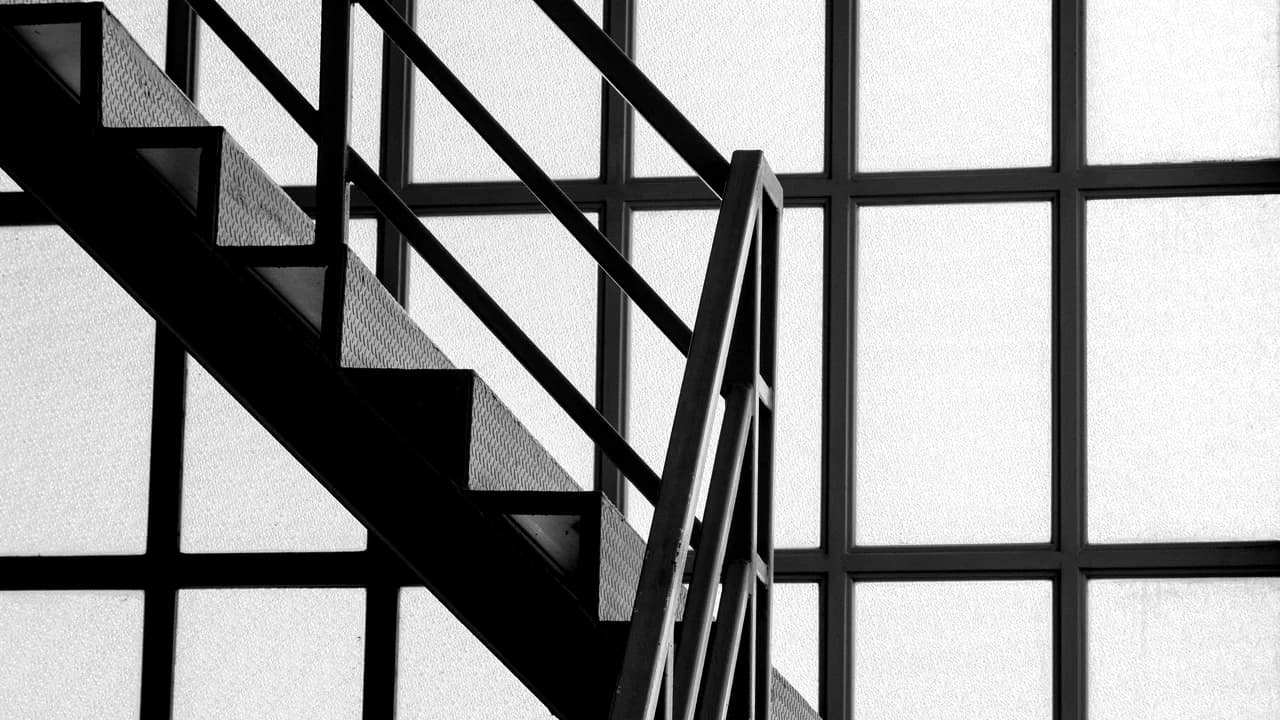 A staircase with a black iron railing