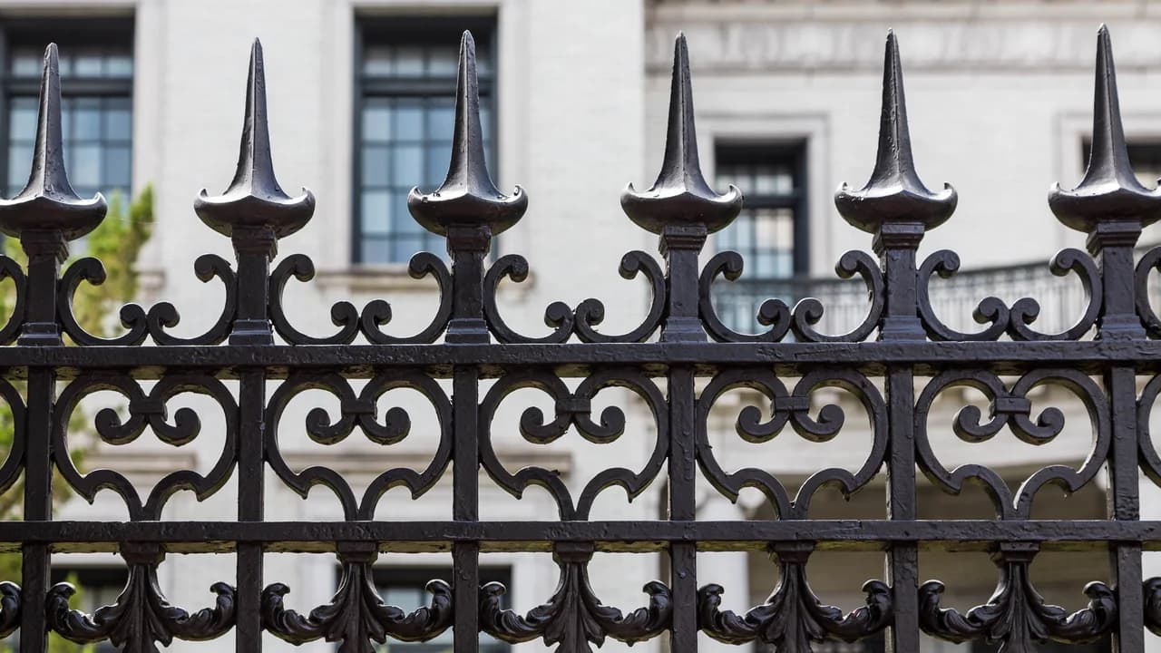 A black wrought iron fence with spear-top pickets